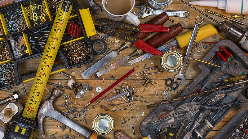 Untidy workbench full of dusty old tools and screws
